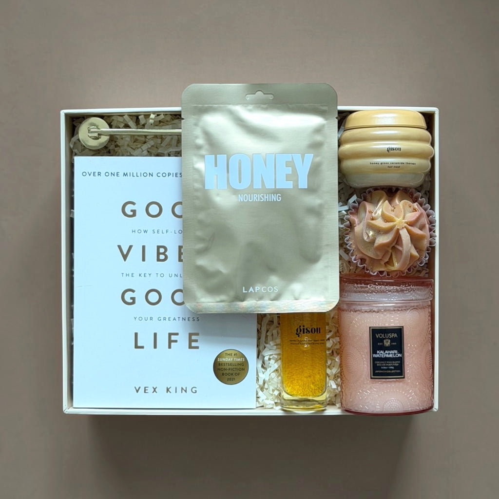 BGIFT luxurious self-care gift set featuring Gisou haircare, Lapcos honey mask, Voluspa candle, and a wellness book.